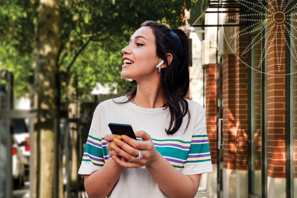 young woman sitting on a comfy couch and using her phone